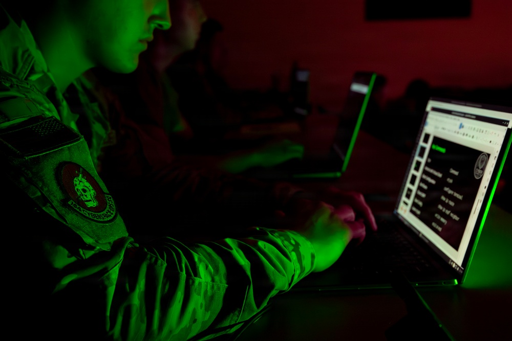 Opérateur travaillant sur plusieurs postes informatiques lors d’un entraînement cyber